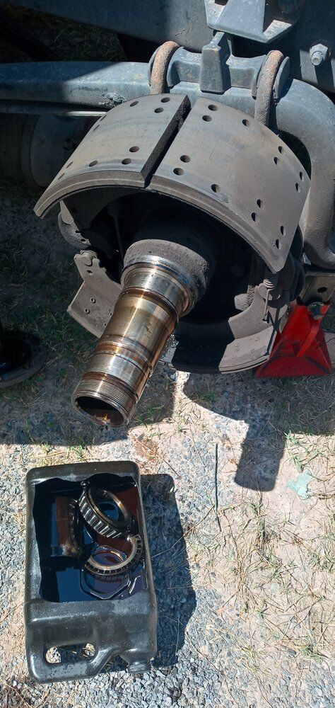 Brake drum and hub assembly disassembled on the ground with tools laid out