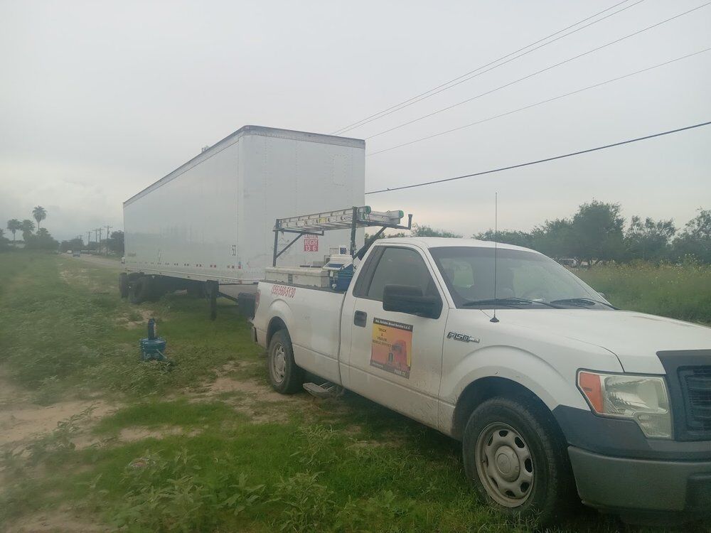 Service truck parked beside a dry van trailer on a roadside call in the Valley