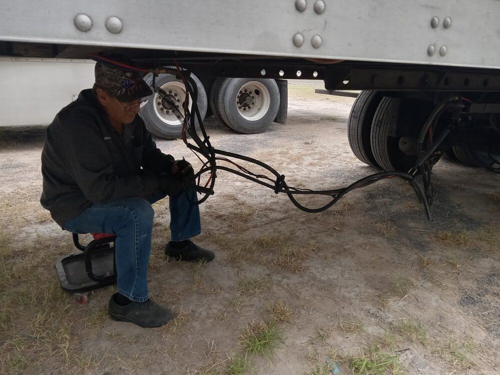 RDZ technician working under a loaded trailer on an air line repair