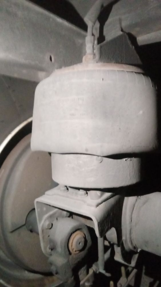 Air spring and suspension mount inspected under a tractor