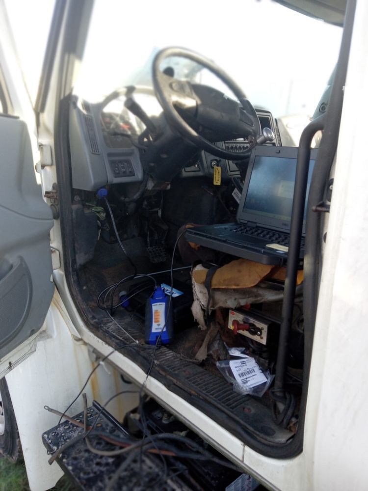 Diagnostic laptop set up in a truck cab while reading engine fault codes