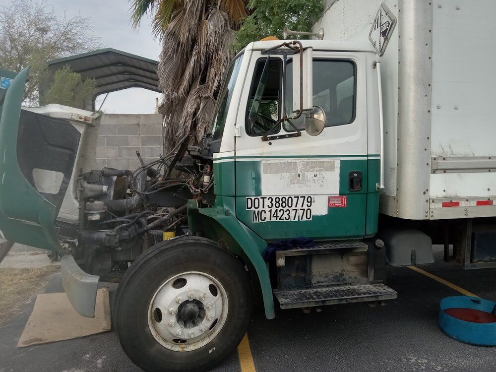 Freightliner box truck with the hood up for a roadside repair in Pharr, Texas